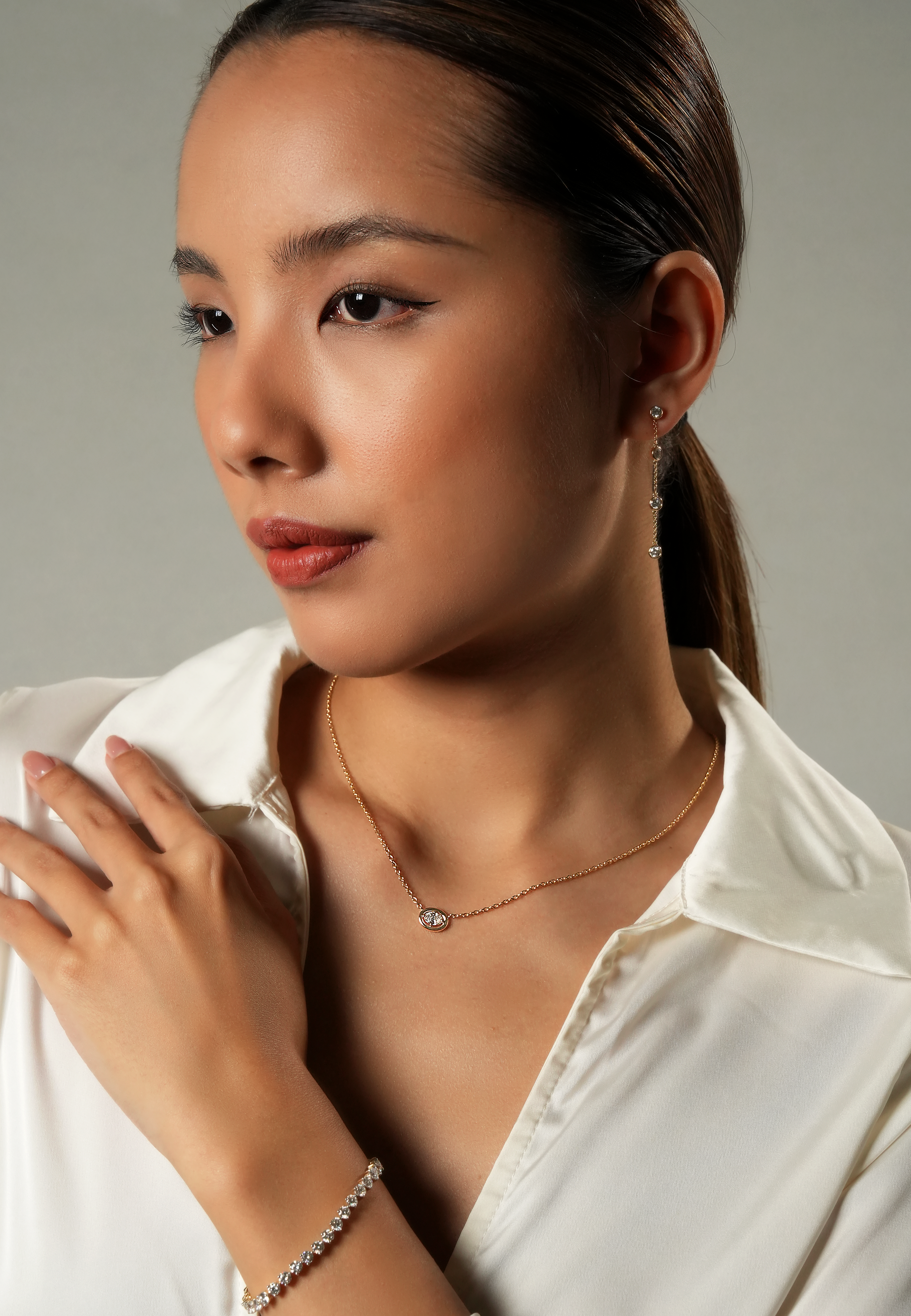 Woman wearing a Oval Cosmic Diamond Necklace against a neutral background