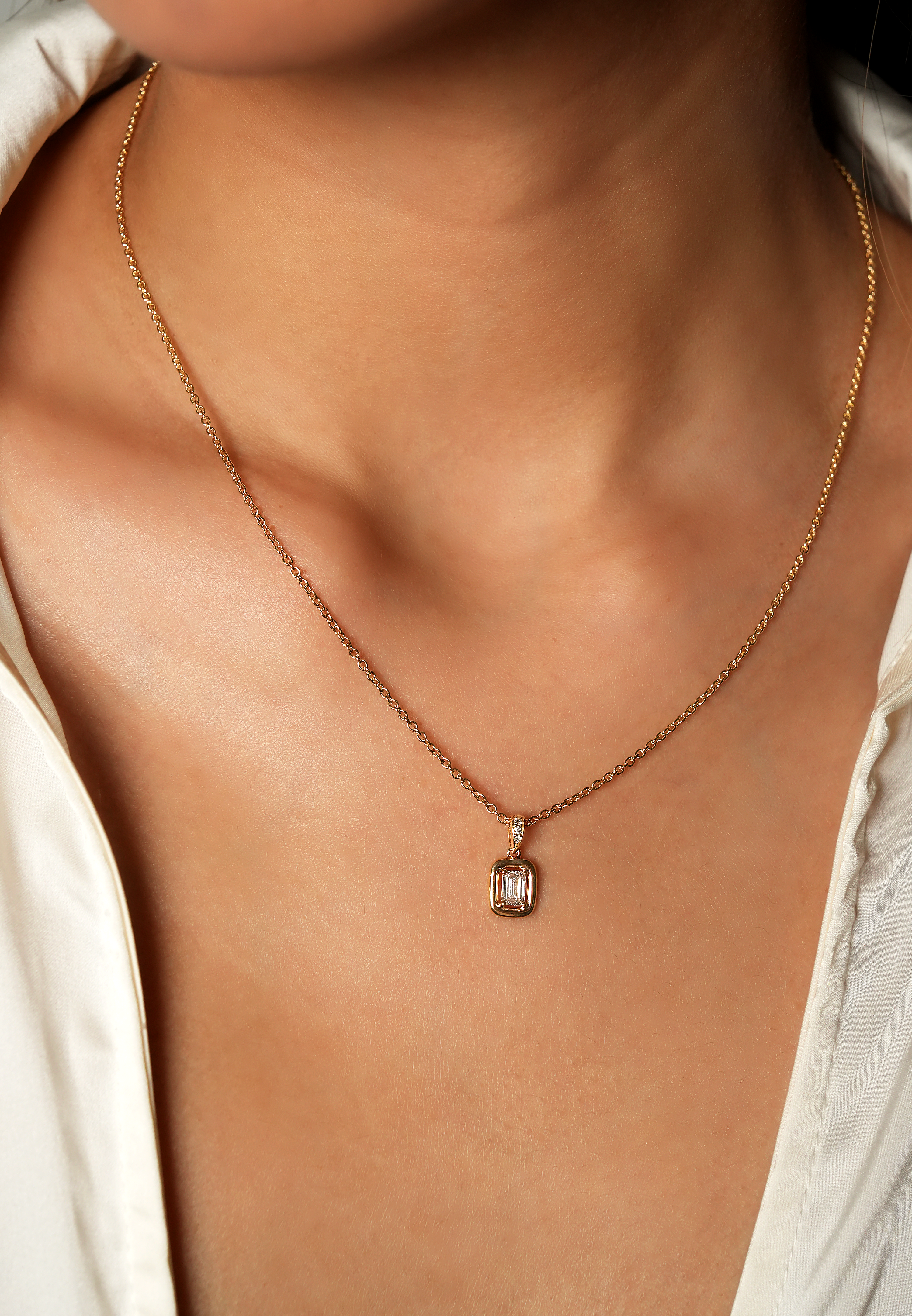 Necklace with a pendant on a person wearing a white shirt